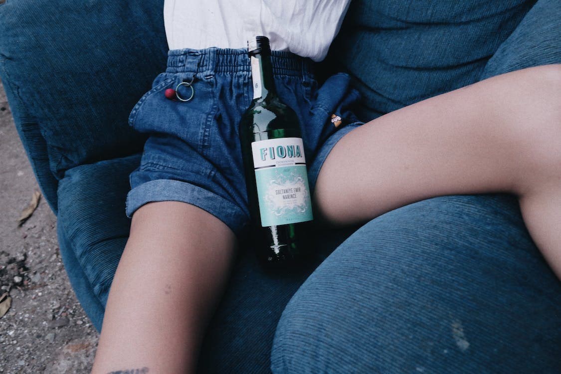 Wine bottle sitting on a woman's lap